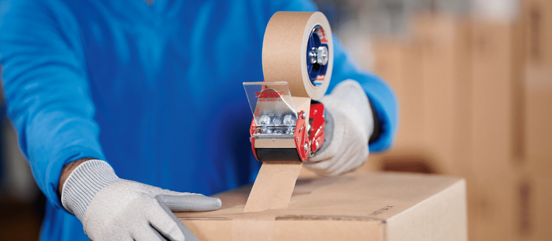 Placing tape on a corrugate box using a tape gun.
