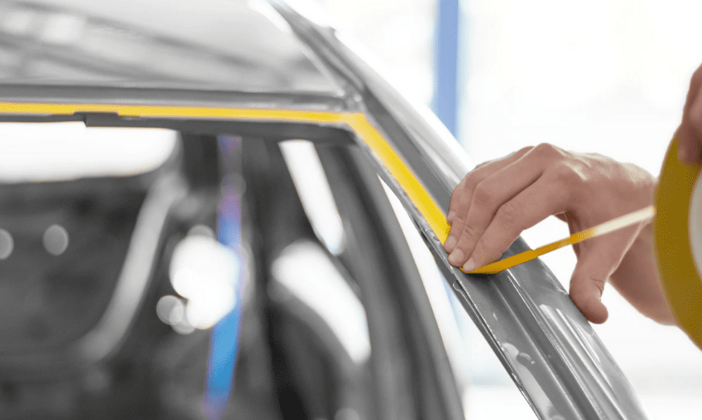 Yellow Tesa Automotive tape being applied to the inner lining of a vehicle frame.