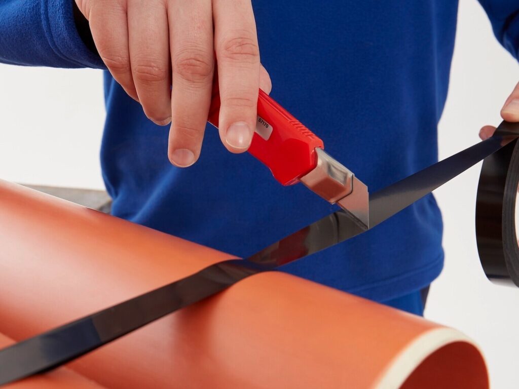 Strapping tapes, bundling a set of tubes and being cut with an exacta knife.