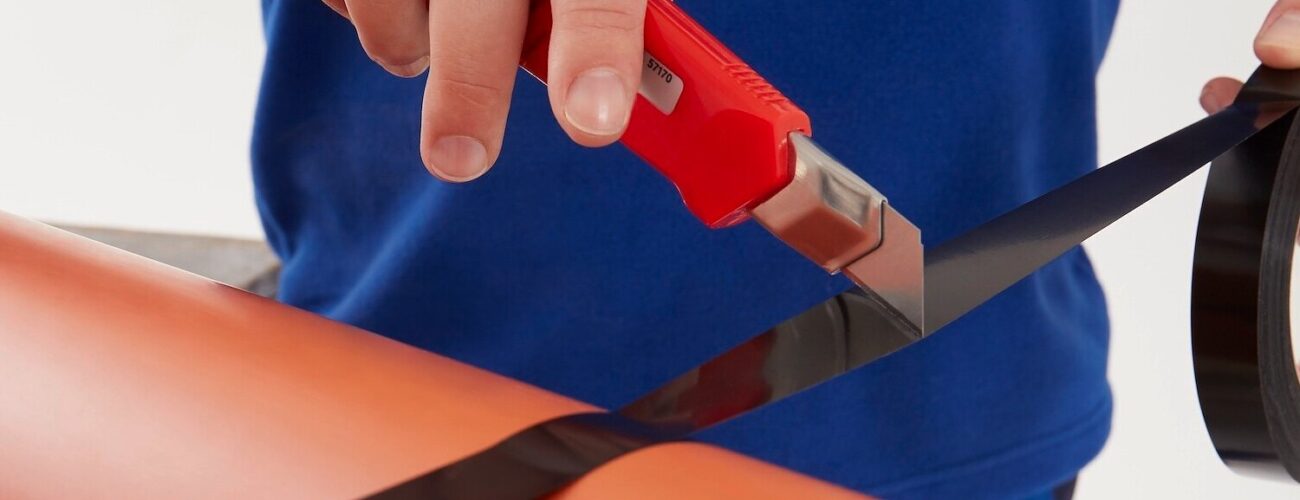 Strapping tapes, bundling a set of tubes and being cut with an exacta knife.