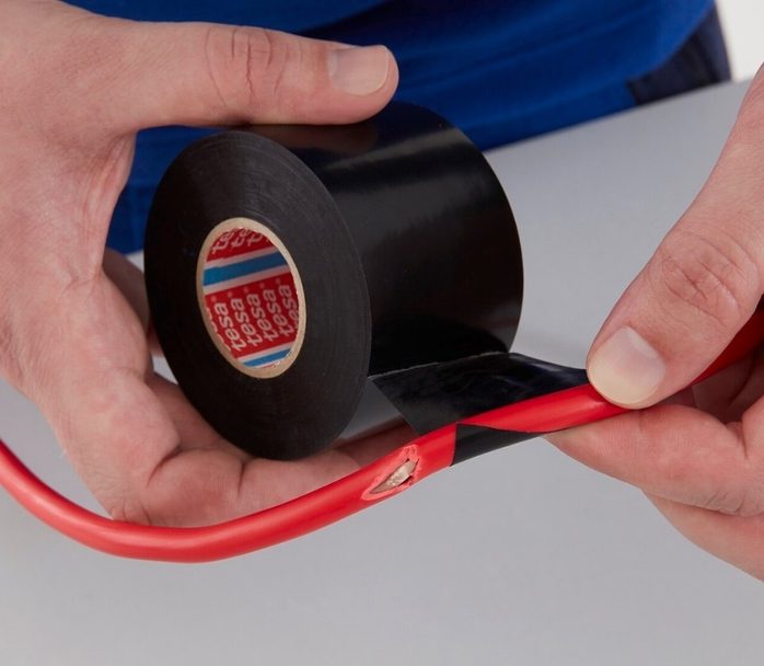 Tesa electric tape being applied to a wire.