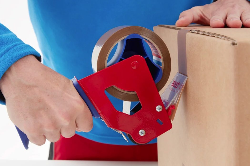 General purpose tape dispenser being used to close up a corrugate box.