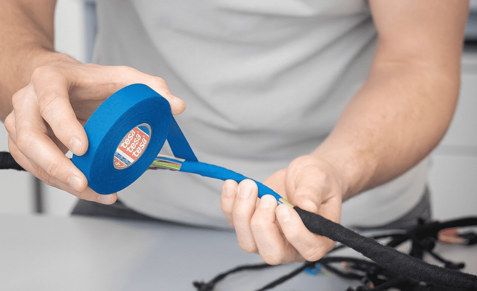 Vinyl bundling tape being applied to wires